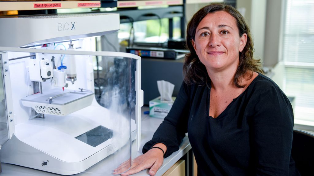Ross Sozzani next to a 3D bioprinter she uses for her research