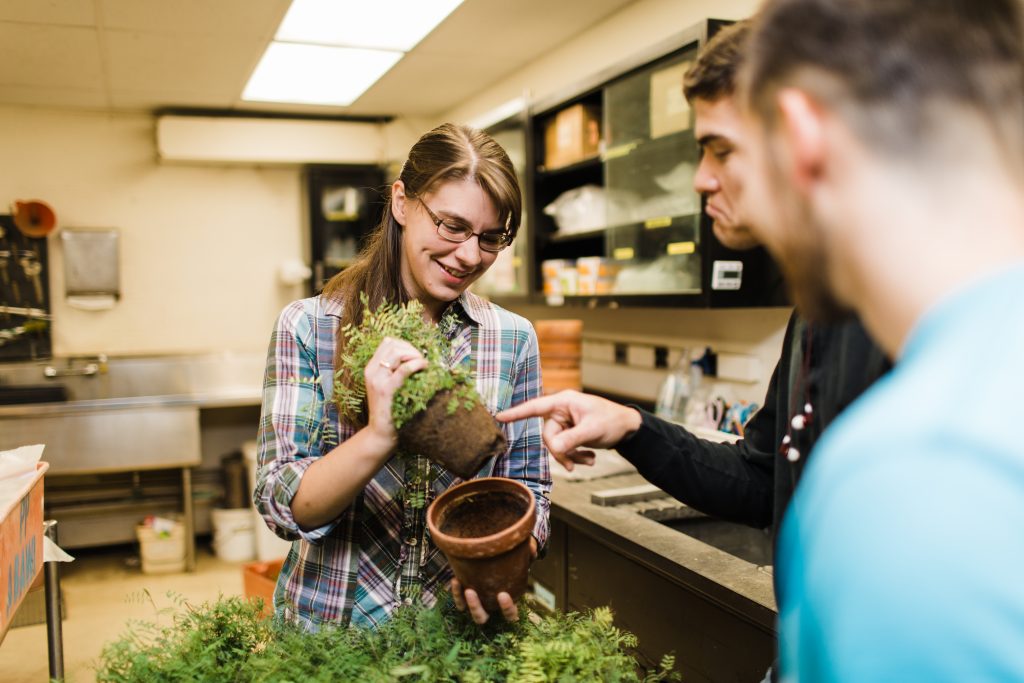 Adrienne Gorny looks at plants with students.