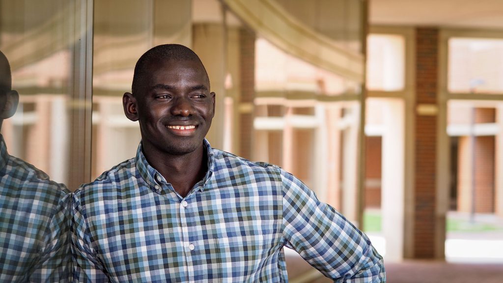 Incoming student Balla Ndure stands outside a building on campus.