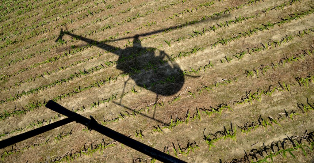 helicopter flies over field