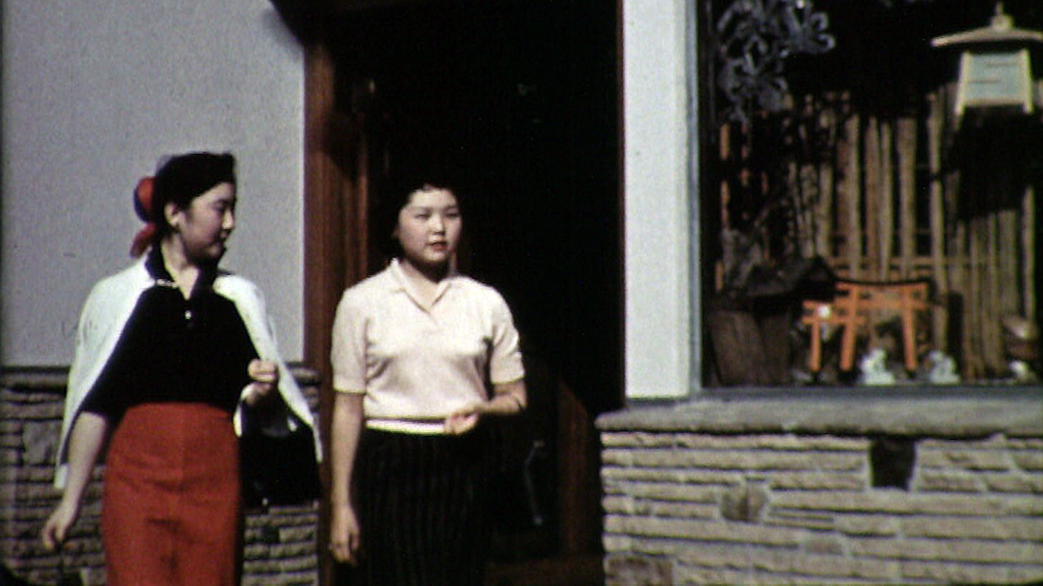 two asian-american girls walk down the street