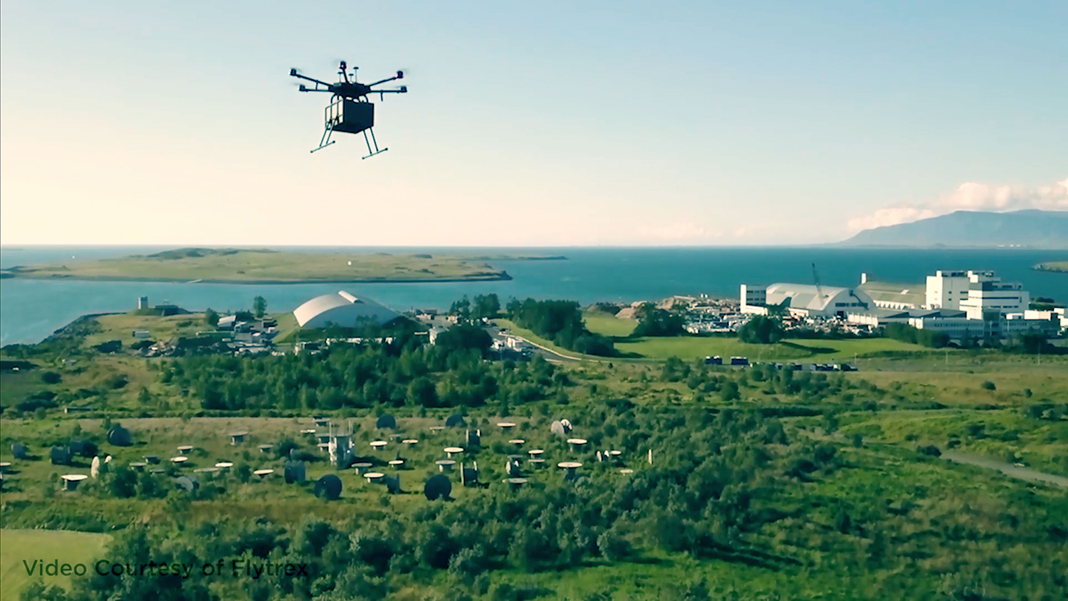A drone flies over the skyline with a package