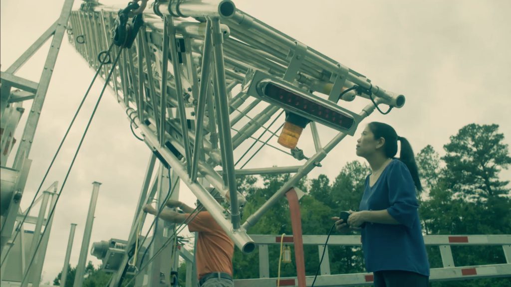 A woman oversees the construction of a mobile tower