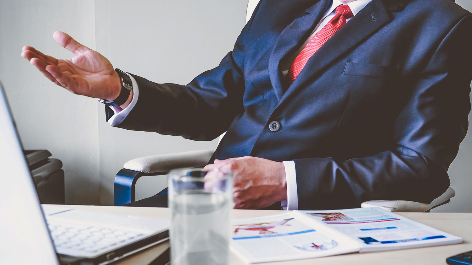 man in suit behind desk