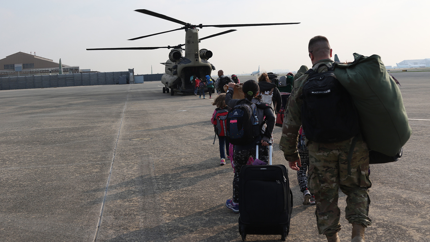 noncombatants boarding a military transport helicopter