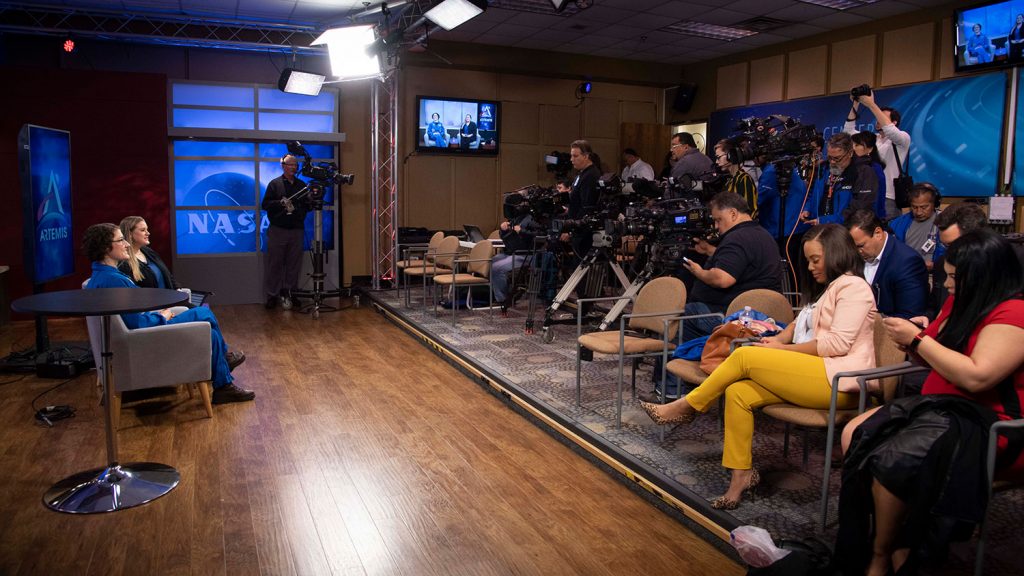 Astronaut Christina Koch answers questions at a press conference.