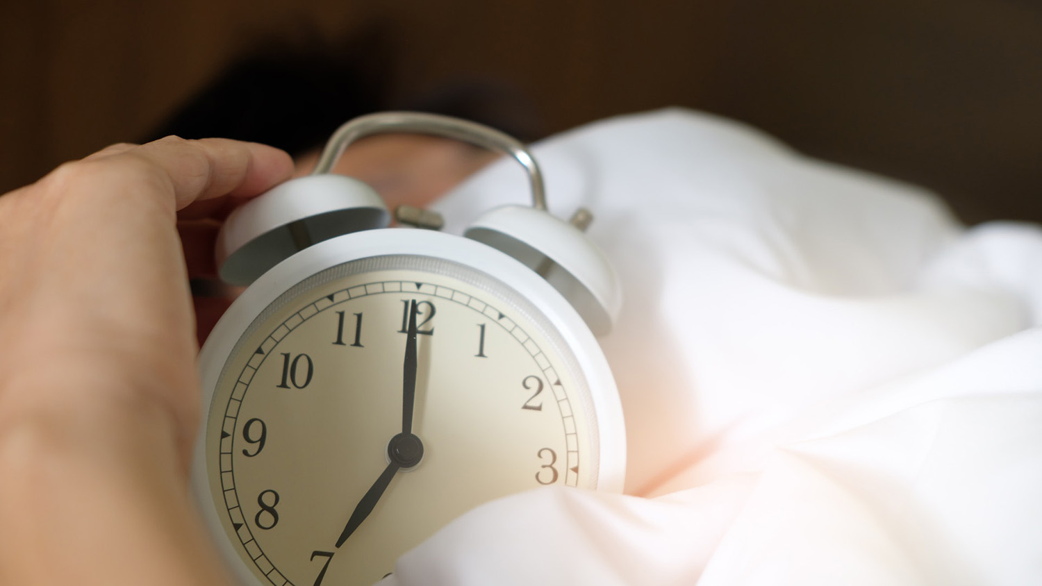 hand holding alarm clock