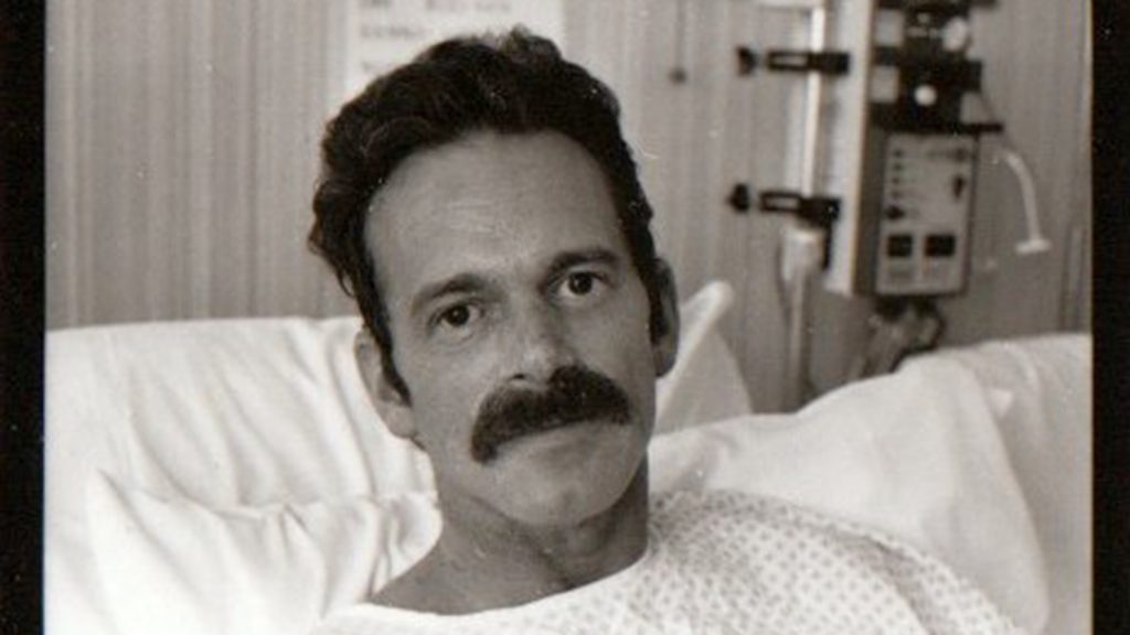 Robert Bland in a hospital bed.