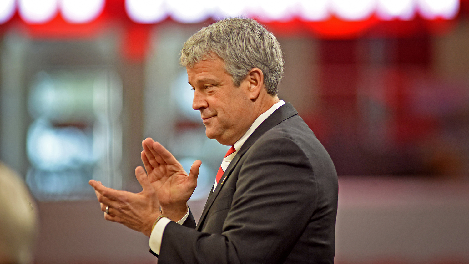 Athletics Director Boo Corrigan applauds as he introduces his family during a press conference in Reynolds Coliseum.