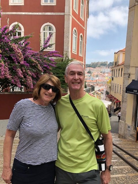 Man and woman posing on cobblestone street in Europe