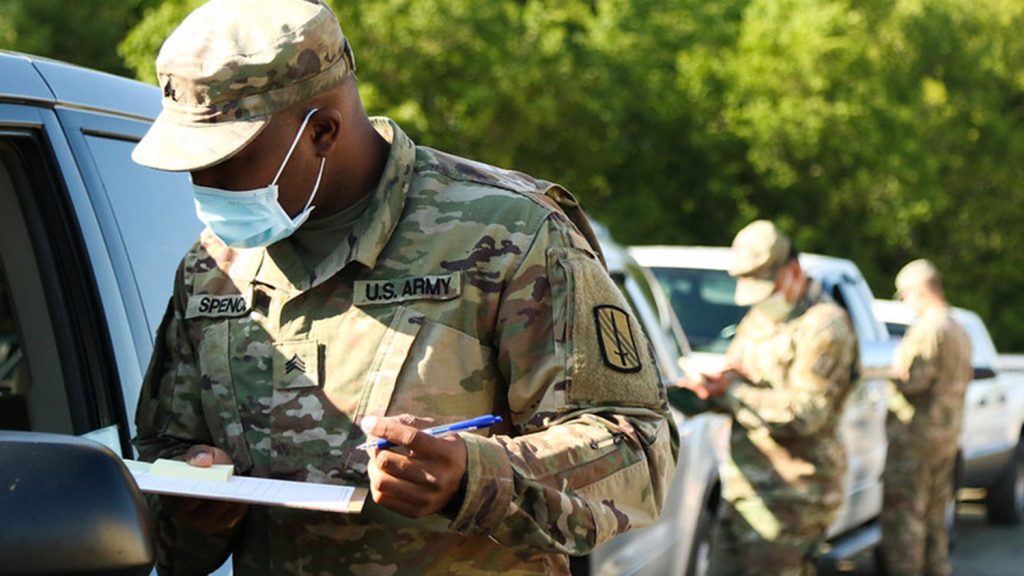 Members of the North Carolina National Guard talking with people in their cars about food distribution