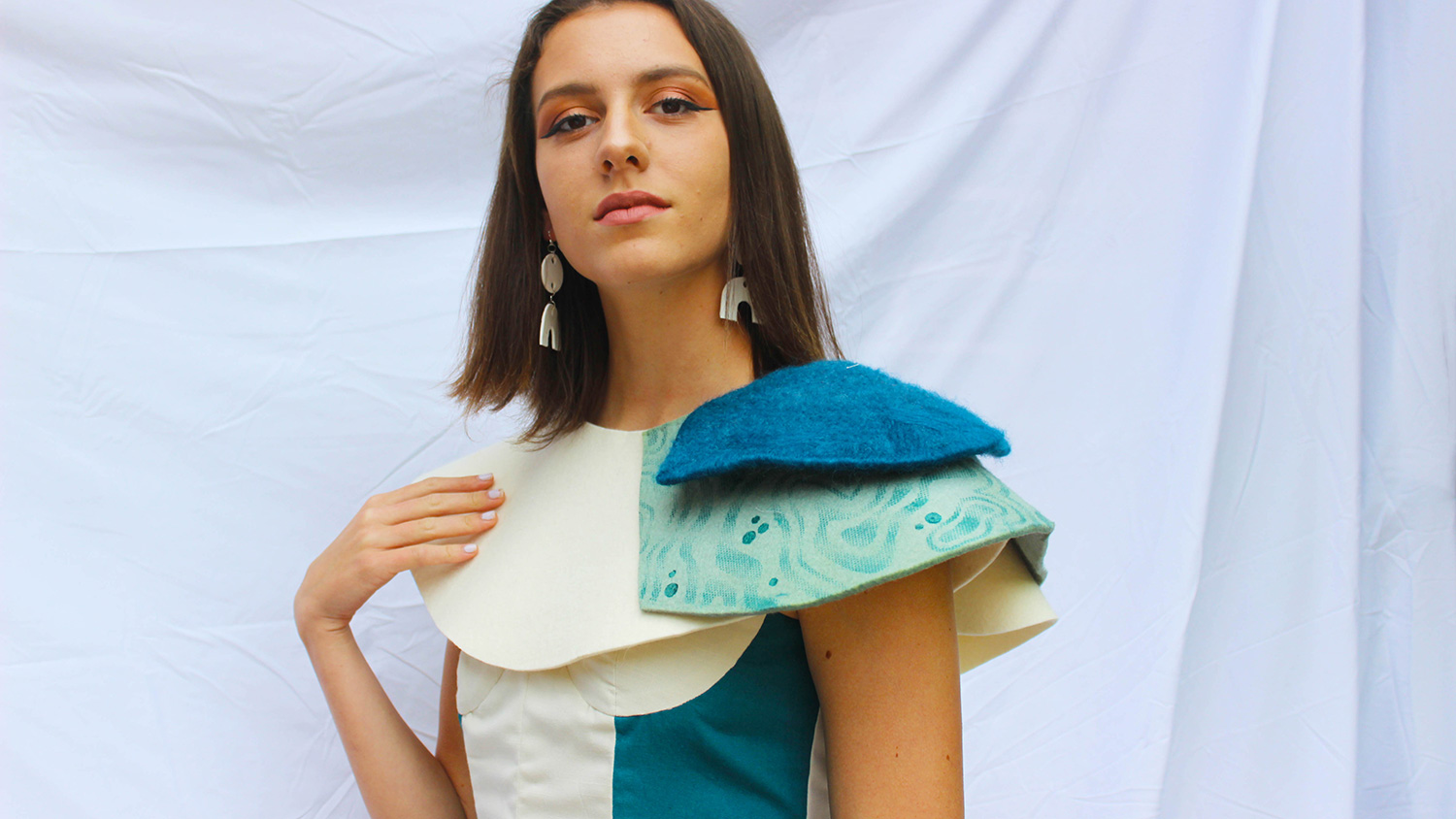 A student models a colorful blue and white garment created for Art2Wear.