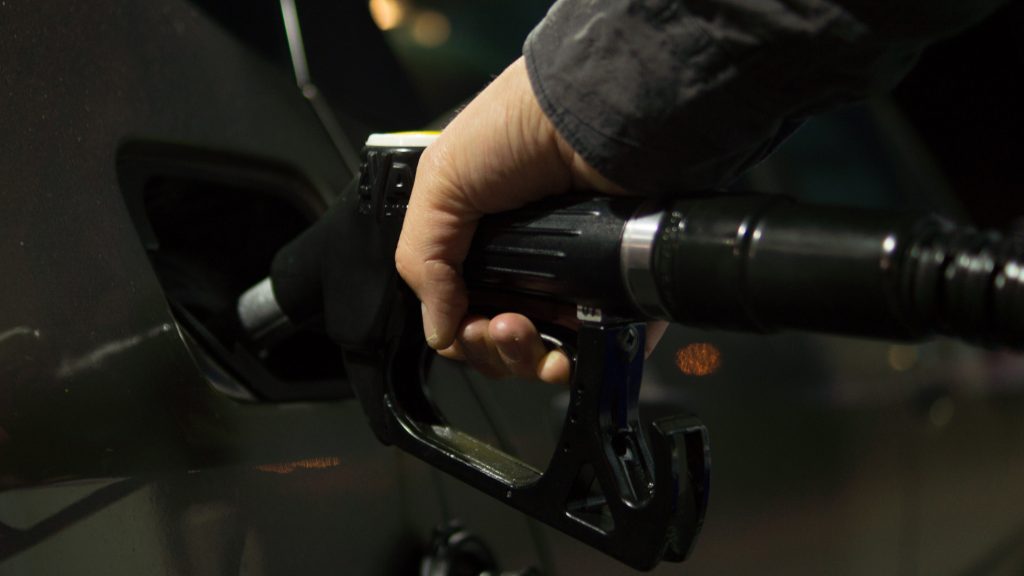A person refills a car's gasoline tank.