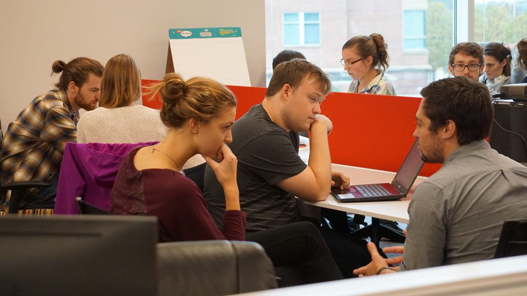 Graduate students brainstorm together in small groups