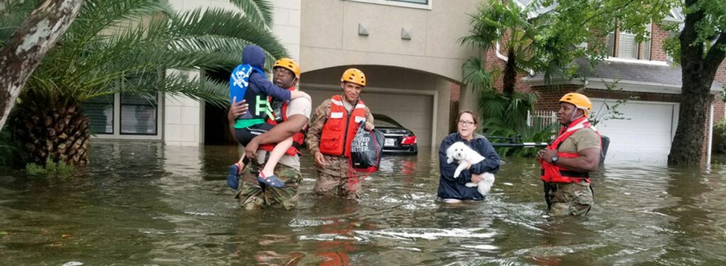 military personnel help family evacuate in waist-deep flood waters