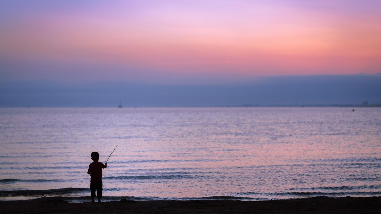 Silhouette of a child fishing.