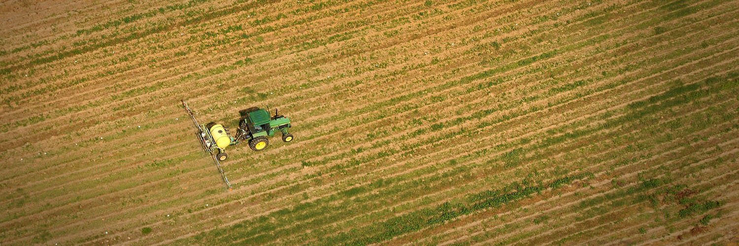 Aerial of tractor spraying fields at Lake Wheeler Farms.