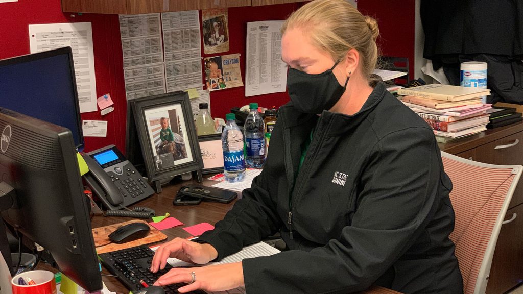 woman at desk wearing a mask