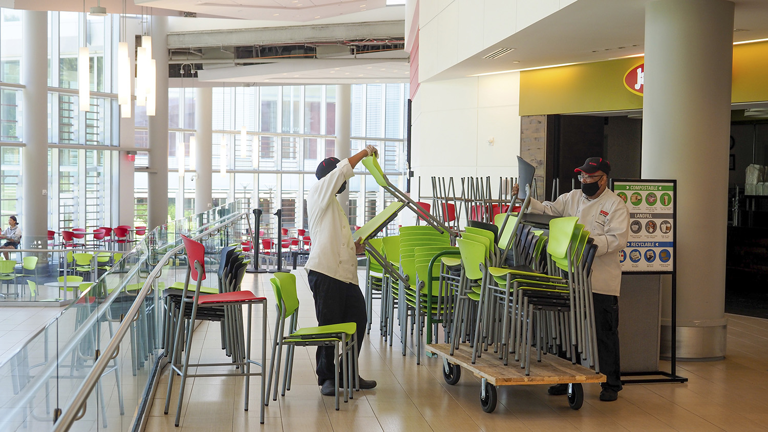 Workers remove green chairs from Talley Student Union to limit seating capacity during the COVID-19 pandemic.