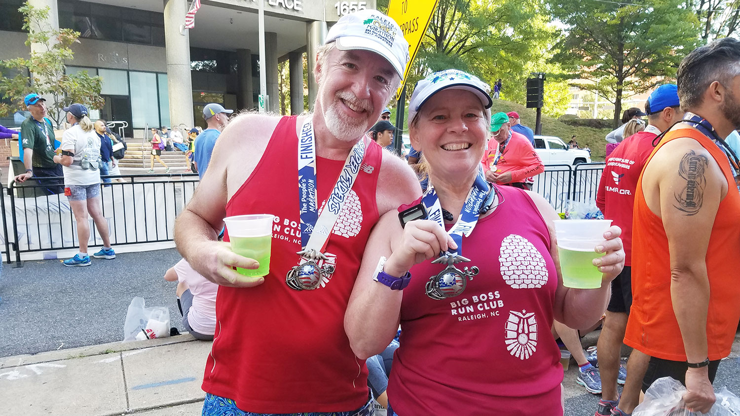 man and woman wearing marathon medals after a race