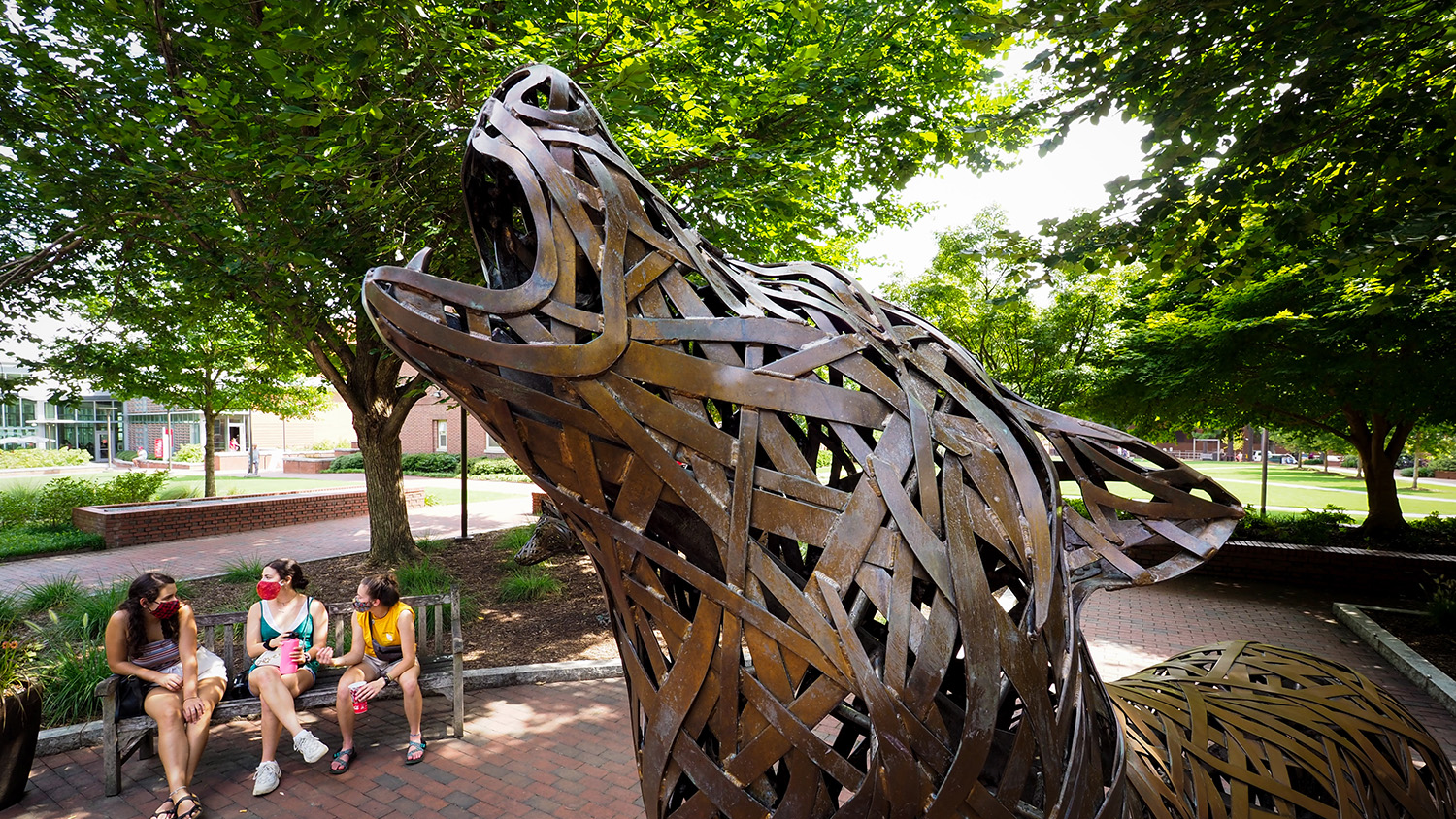 Three incoming freshman, wearing their masks, chat together in Wolf Plaza during COVID-19 move in 2020. Photo by Marc Hall