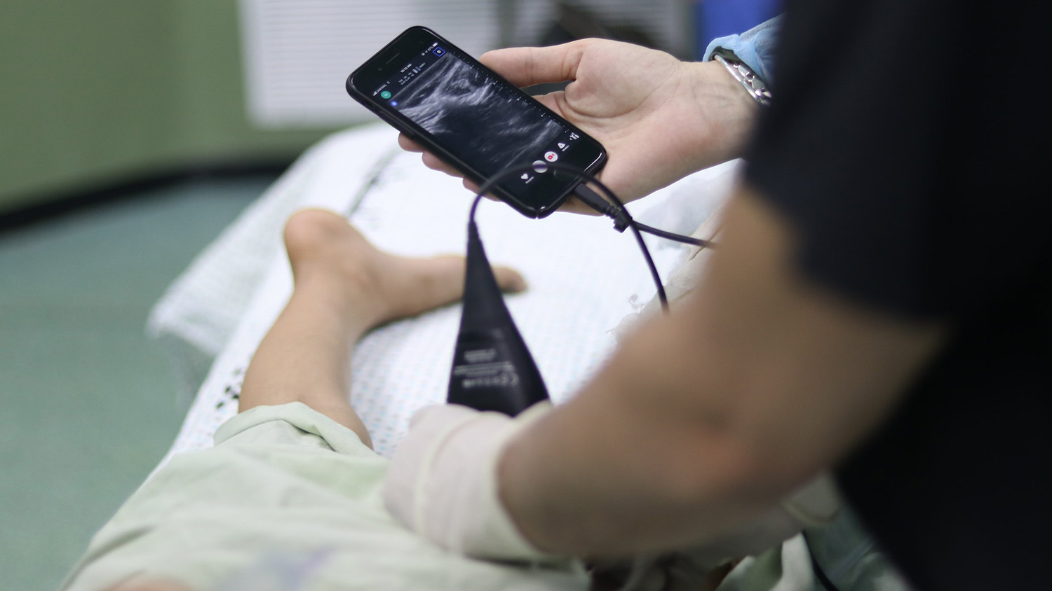 healthcare workers use ultrasound connected to a smartphone in an emergency room