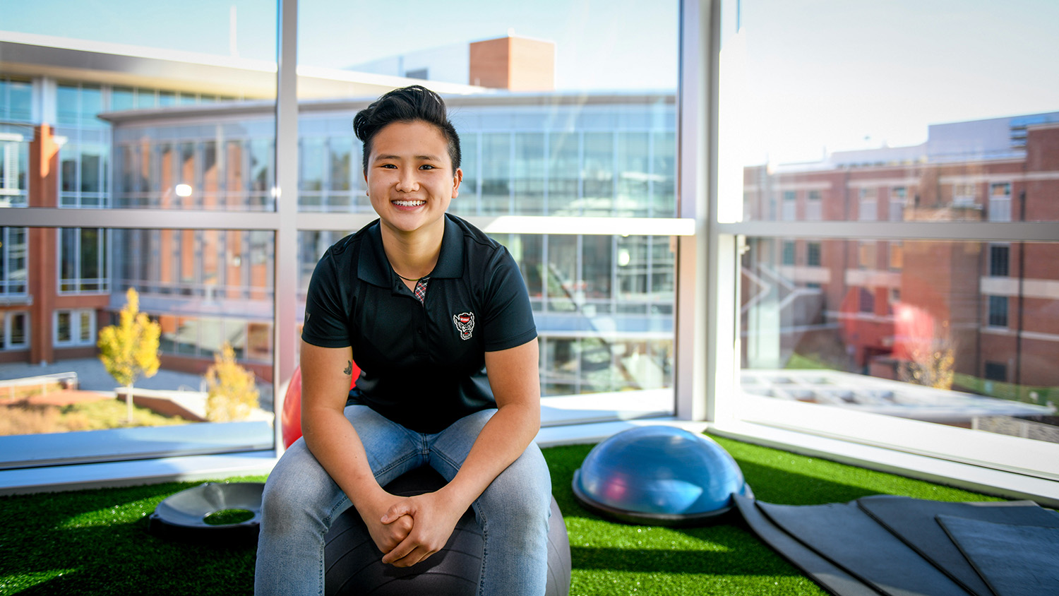 Alyssa Cox sits on a balance ball inside the Wellness and Recreation Center for a portrait.