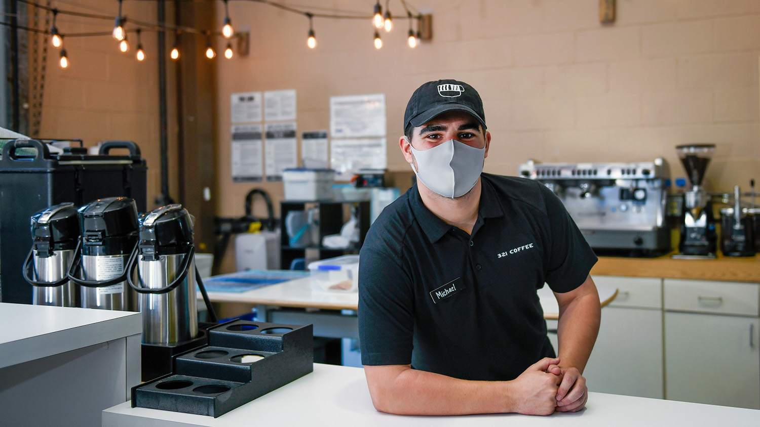 Michael Evans stands behind the counter of 321 Coffee for a portrait.