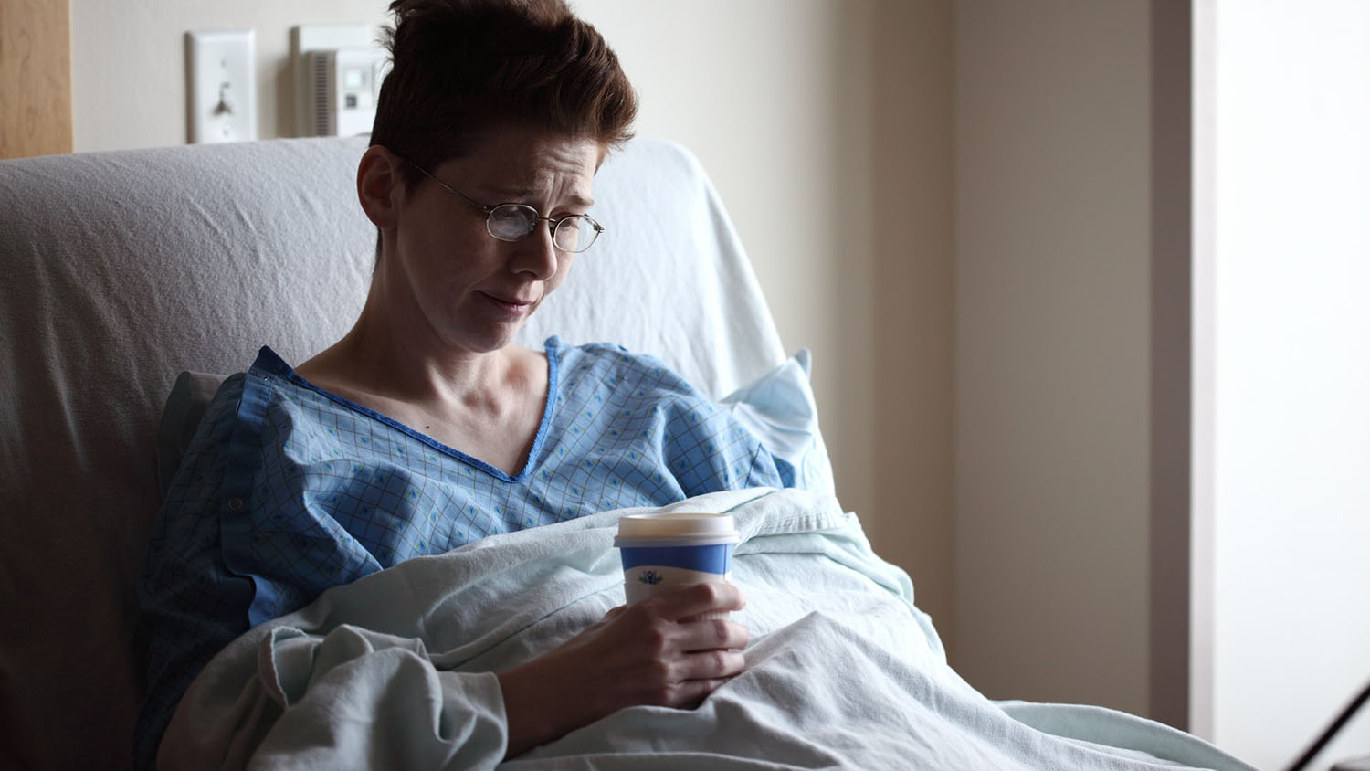 person in hospital bed looking stressed