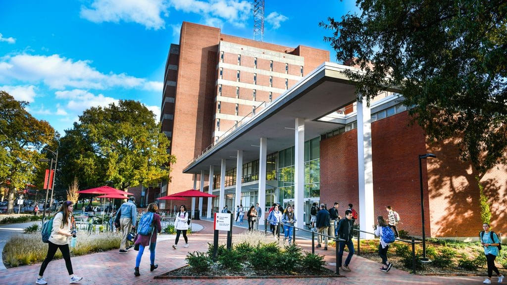 An exterior shot of D.H. Hill Jr. Library with students flooding inside.