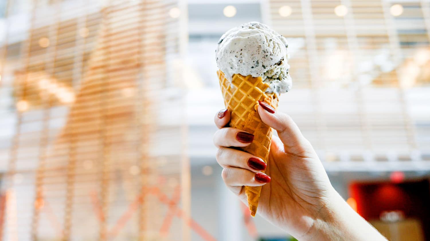 A scoop of cookies and cream ice cream in a waffle cone.