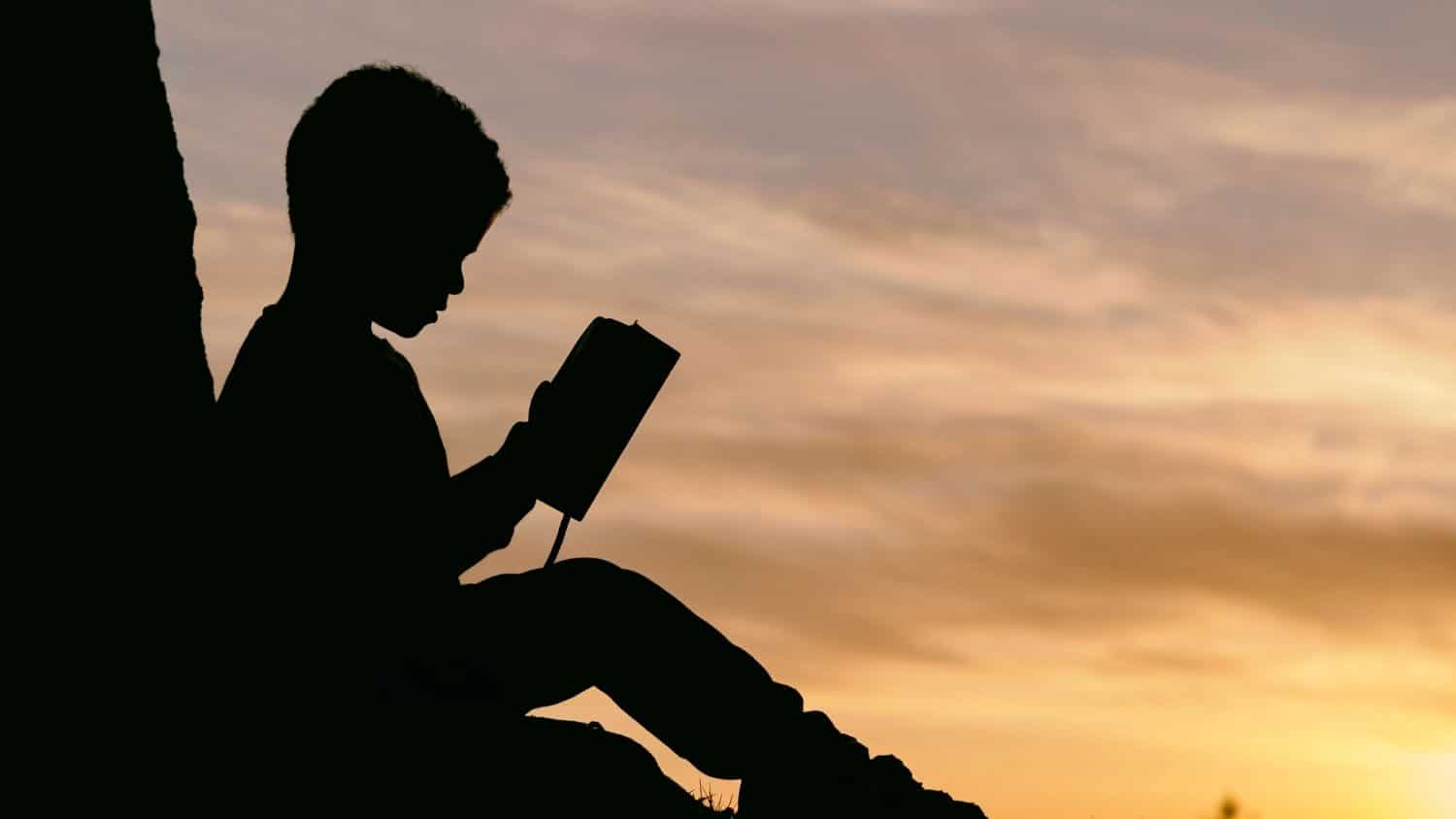 Child reading at sunset.