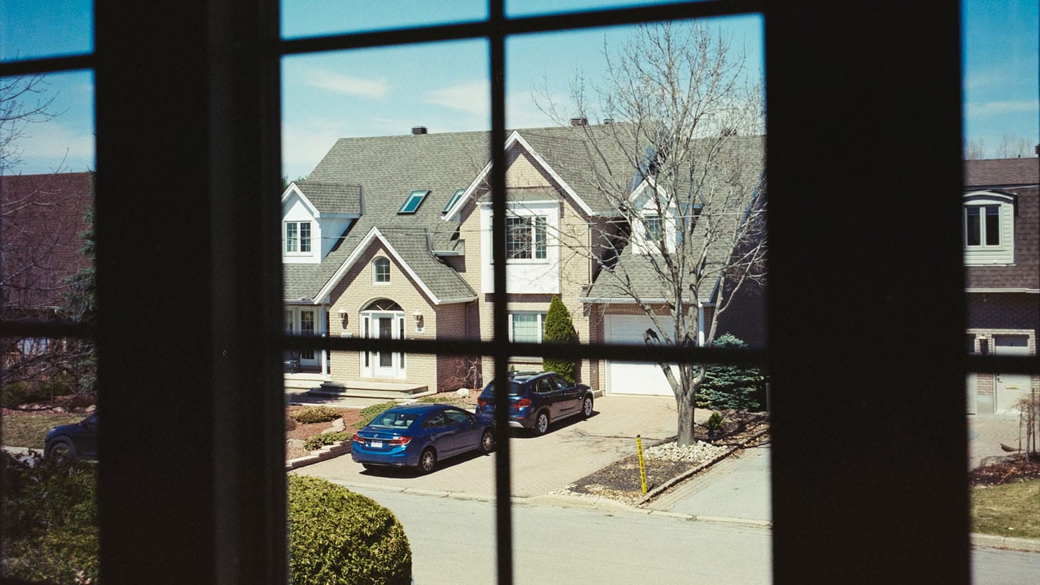 view of a suburban street from the window of one of the homes