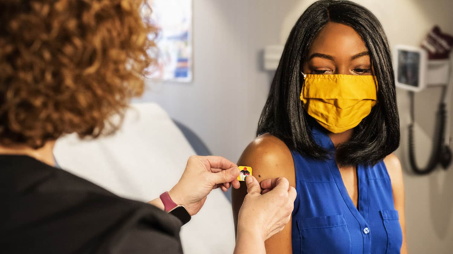 young woman in mask receives vaccine shot