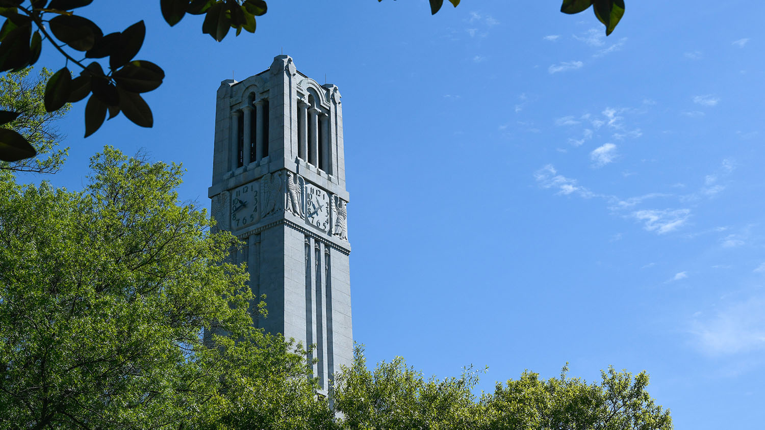 The NC State belltower, framed against a clear sky.