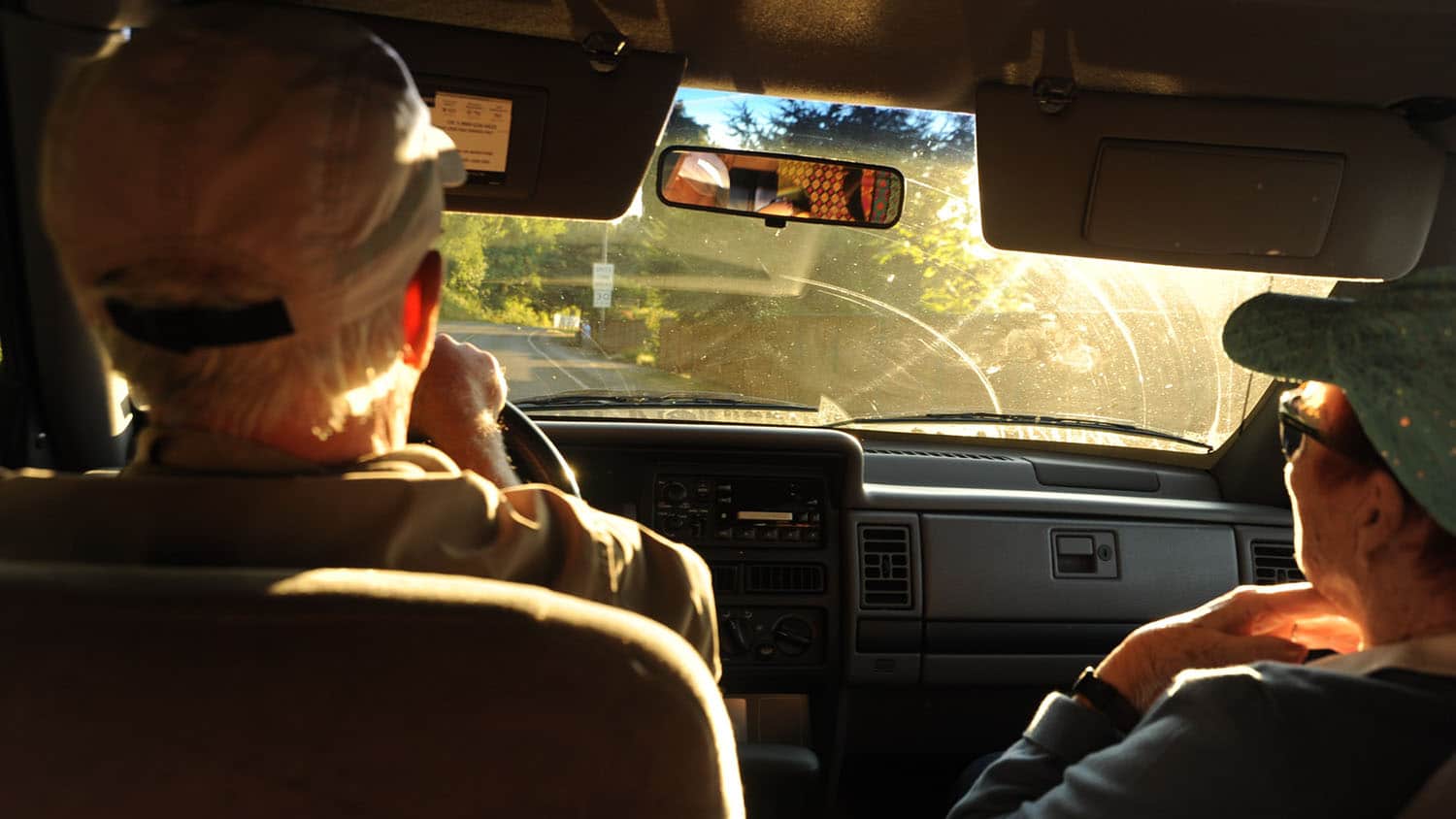 Older man and woman in front seat of a car.