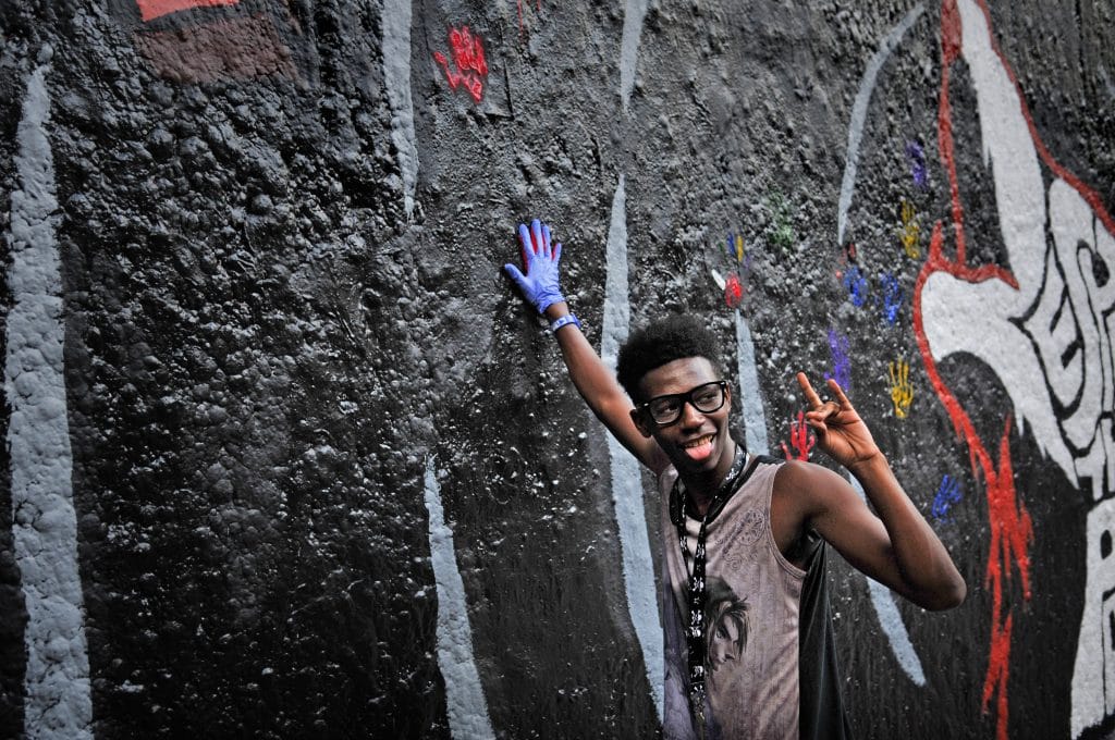 A young man makes a handprint on the wall at the Respect the Pack event.