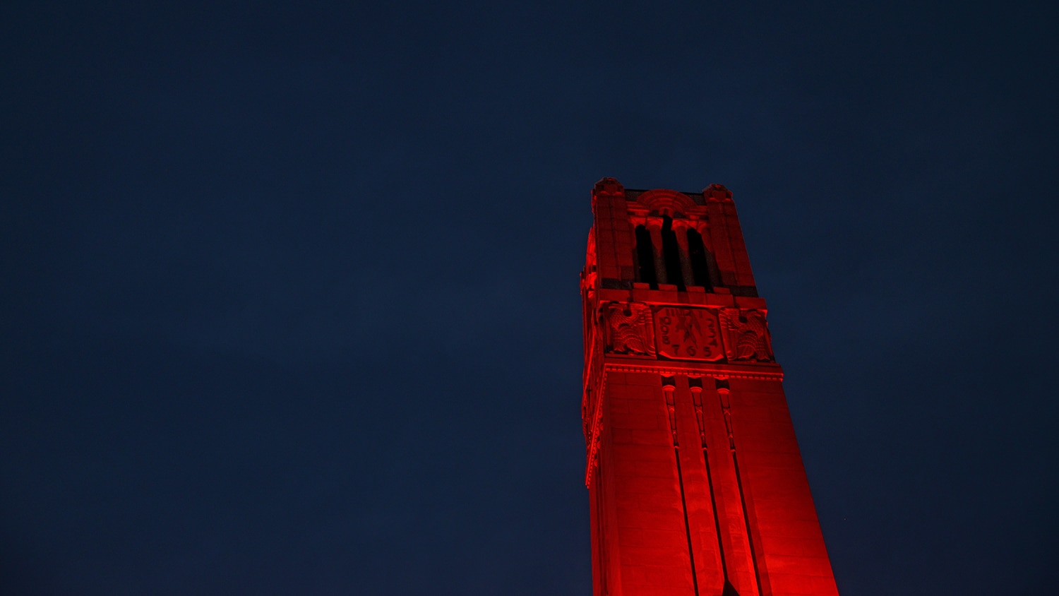 NC State's Memorial Belltower lit red.