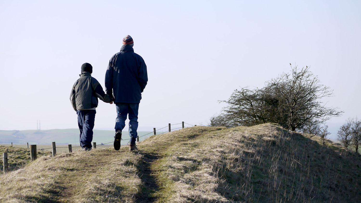 man and boy in silhouette, going for a walk together