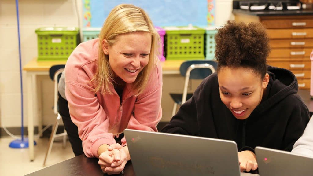 student and teacher at laptop