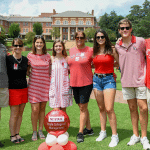 A multigenerational family poses in the Court of North Carolina wearing red.