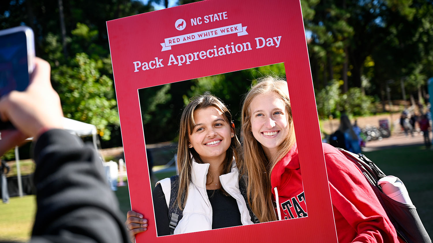 Two women pose with a poster that says "Pack Appreciation Day."