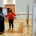 A student presents her poster at the research symposium.