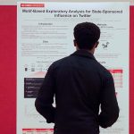 A student reads a poster at the research symposium.