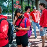 Students line up outside of Guasaca on Hillsborough Street, donning red apparel.