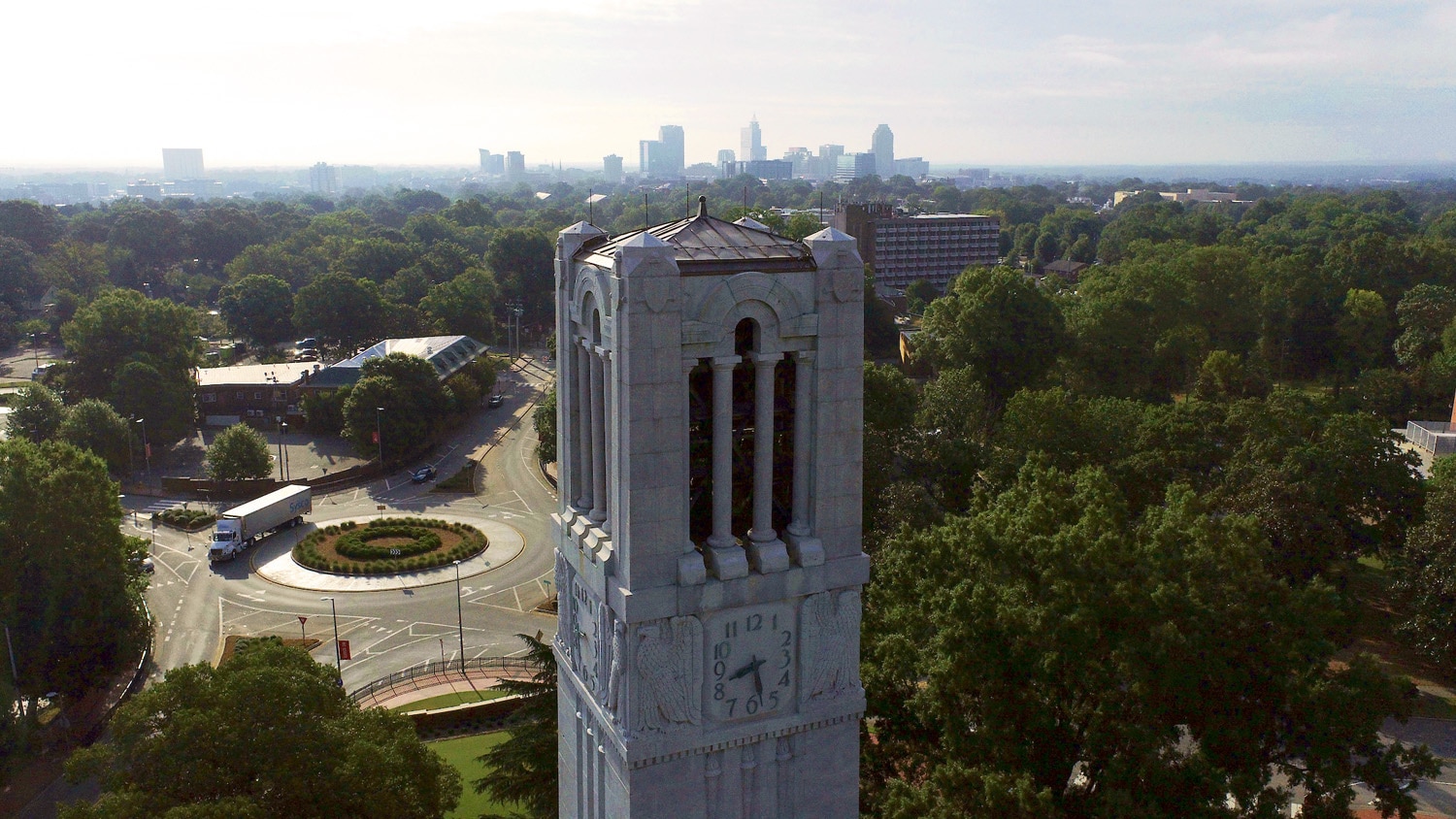 The Memorial Belltower with the Raleigh skyline in the background.