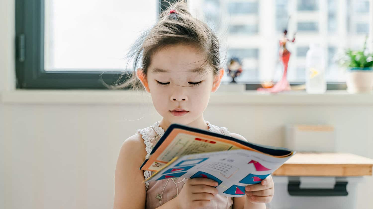 young girl reading a picture book