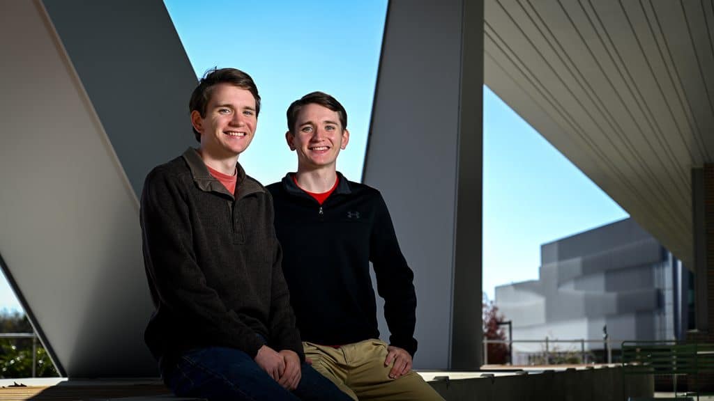 Ryan and Andrew Bennison outside Fitts-Woolard Hall, with the Hunt Library in the background