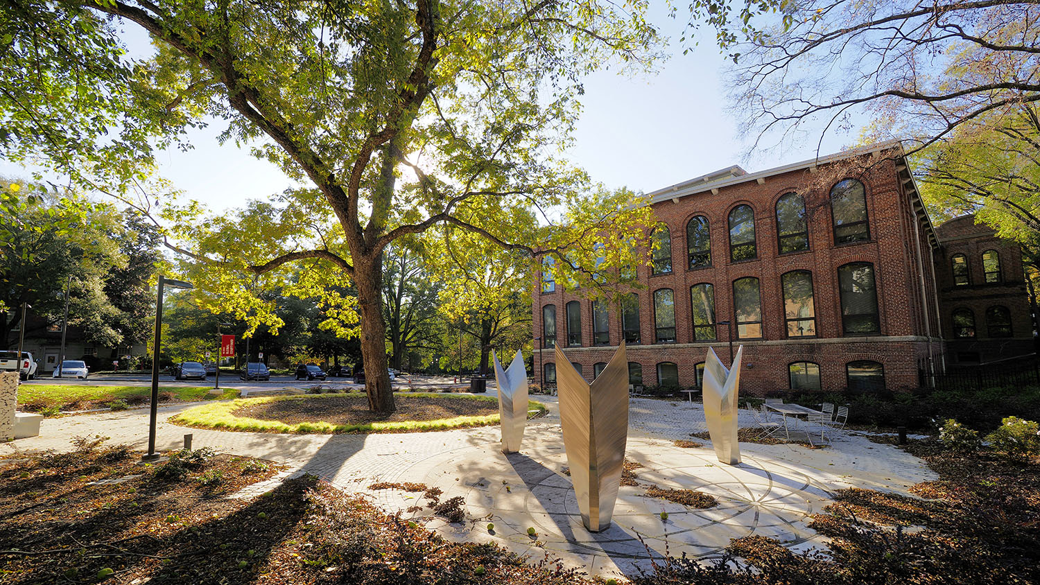 A photo features three statues at the Global Courtyard on a sunny day.