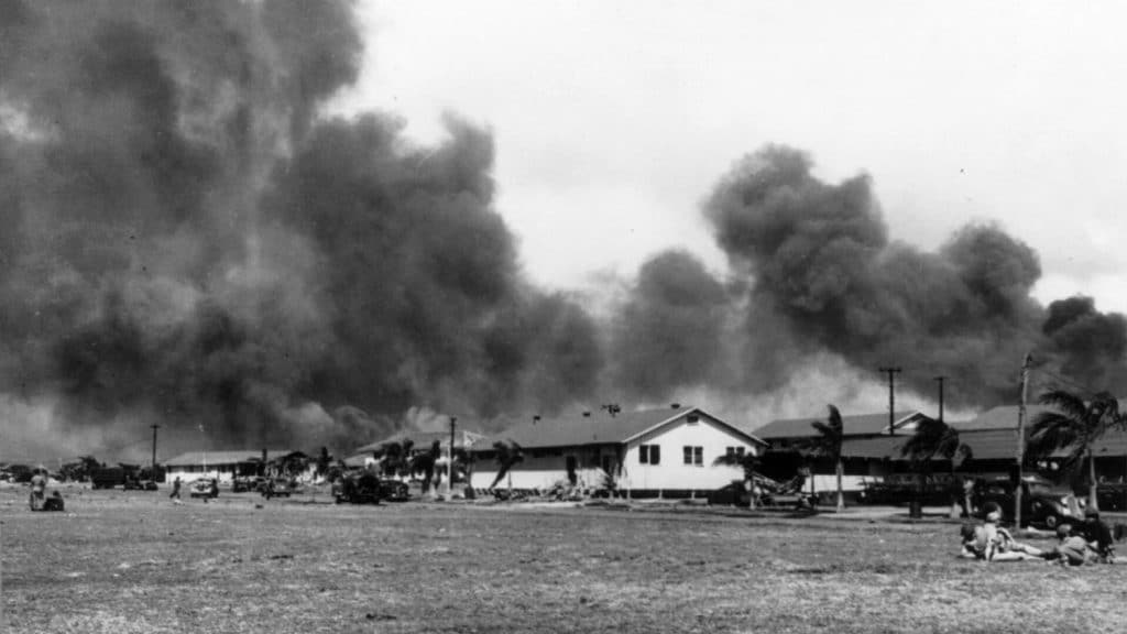 View of the barracks from parade ground off Hangar Avenue at Hickam Field, Hawaii, during the Japanese attack on Pearl Harbor. Photo: National Park Service.